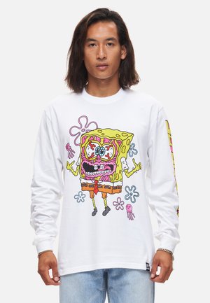 Long-sleeve white shirt featuring a colorful cartoon graphic of SpongeBob with exaggerated features, alongside pink jellyfish and flowers.