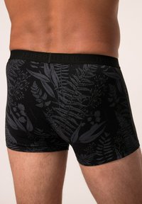 Caleçons boxers noirs avec un motif floral sombre, ceinture élastique avec un marquage "JP1830", et un design ajusté avec une texture lisse.