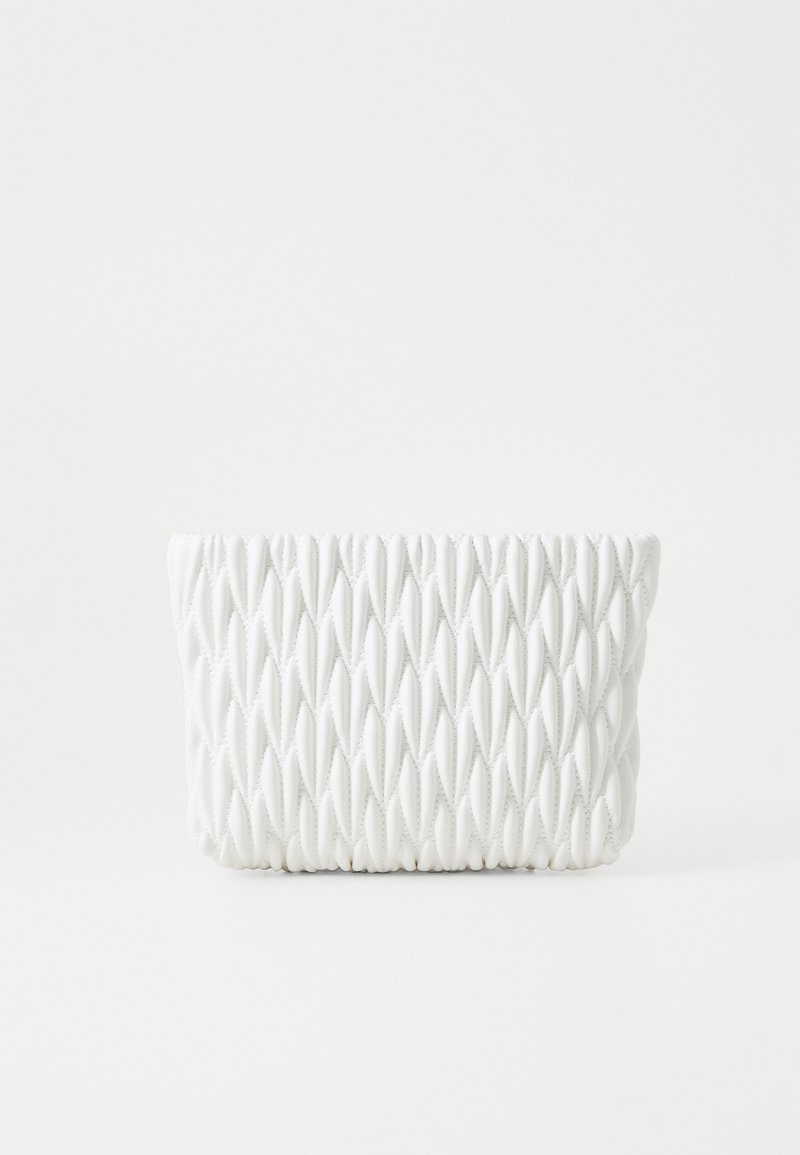 Valkoinen teksturoitu clutch-laukku, jossa on geometrinen kuvio, pyöreitä muotoja ja ommeltuja yksityiskohtia, valmistettu pehmeästä materiaalista.