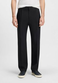 Black tailored trousers featuring a flat front, side pockets, and a straight-leg design. Made of smooth fabric with a slight sheen.