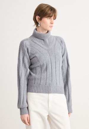 Maglione grigio lavorato a maglia con un alto colletto a coste, strisce verticali testurizzate e orlo a coste aderente. Maniche lunghe con polsini a coste.