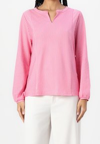 Vaaleanpunainen raidallinen pitkähihaisuus paita, jolla on rento istuvuus. Siinä on pieni V-pääntie ja kootut hihansuut, valmistettu kevyestä kankaasta.