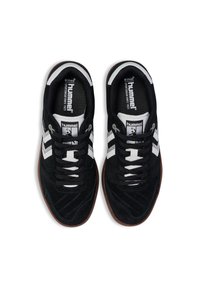 Schwarze Wildledersportschuhe mit weißen Akzenten, ausgestattet mit einer Schnürung, strukturierten Oberfläche und einer braunen Gummisohle.