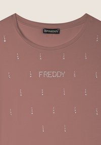 T-shirt rosa a maniche corte con scollo rotondo e strass sparsi. "FREDDY" è in evidenza in strass sulla parte anteriore.