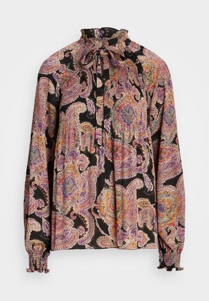 Blouse à manches longues avec col montant à volants et lien, présentant un motif cachemire rose, violet et orange sur tissu noir avec poignets smockés.