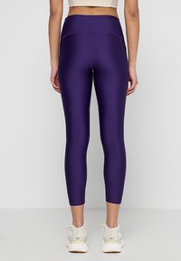Leggings viola a vita alta realizzati in un tessuto morbido ed elasticizzato; silhouette aderente, taglio alla caviglia e dettagli di cucitura rinforzati.