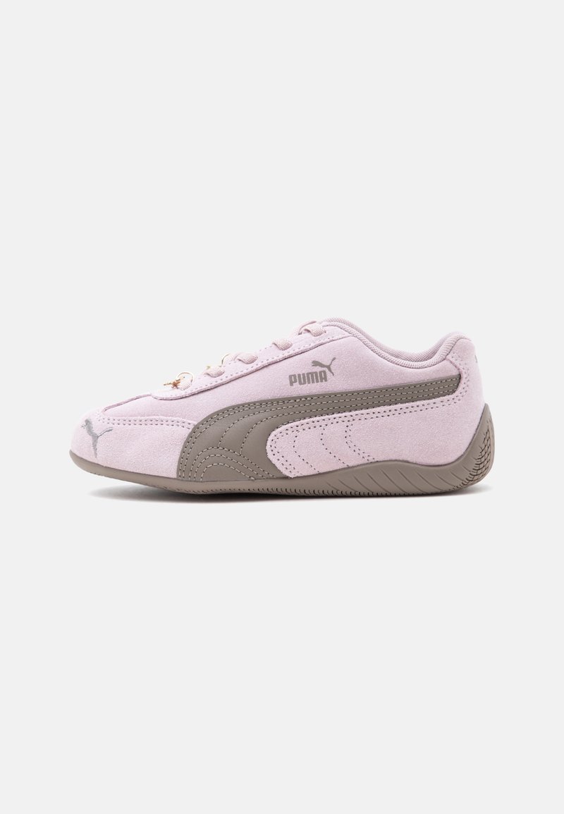 Ανοιχτό μωβ σουέντ αθλητικό παπούτσι Puma με γκρι λογότυπο Puma, γκρι λαστιχένια σόλα και σχέδιο με κορδόνια, σε λευκό φόντο, πλάγια όψη.