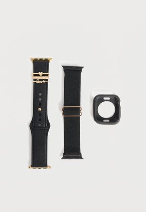 Čierny kožený remienok na smartwatch so zlatým kovaním a príveskami, čierny textilný remienok so zlatou prackou a čierne silikónové puzdro na hodinky na bielom pozadí.