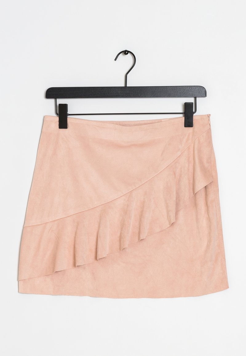 Mini-jupe en daim rose pâle avec un détail de volants en biais sur le devant. Accrochée à un cintre en métal noir. Texture lisse.