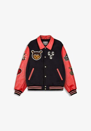Schwarze Collegejacke mit roten Lederärmeln, Kragen, gestreiften Bündchen und Aufnähern, darunter ein Bärenkopf, die Buchstaben GGG und verschiedene Symbole.