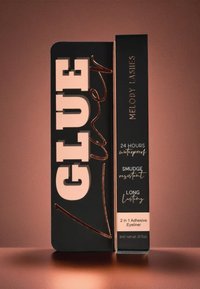 Emballage d'eyeliner adhésif Genuine Melody Lashes, noir avec texte beige et or rose, mettant en avant des caractéristiques waterproof, résistantes aux bavures et longue tenue.