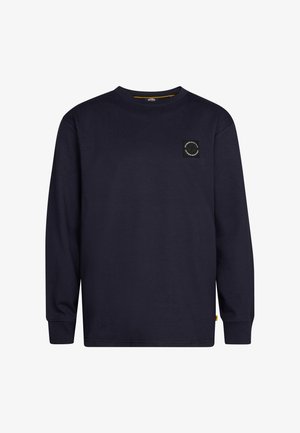 Langärmliges navy T-Shirt mit kleinem weißen Logo, hellblaue gerade Jeans und weiße Sneaker. Minimalistisches Design und lockerer Sitz.