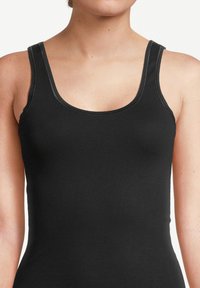 Black tank top with a scoop neckline, thick straps, and smooth fabric texture. Features contrast stitching along the neck and armholes.