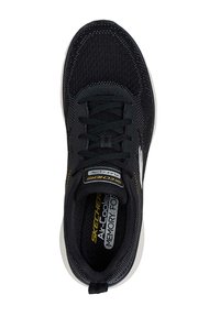 Zapatilla deportiva negra con un upper de malla texturizada, diseño con cordones, cuello acolchado, entresuela blanca y plantilla con marca. Presenta acentos amarillos.