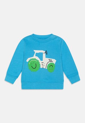 Felpa in cotone blu con grafica di un trattore bianco e ruote verdi a forma di sorriso. Collo rotondo e maniche lunghe con chiusure a pressione.