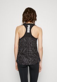 Černý sportovní tílko s listovým vzorem, kulatým výstřihem a designem racerback. Logo "PUMA" v bílé barvě na horní části zad.