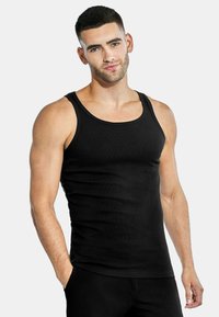 Black ribbed tank top featuring wide straps and a fitted design. Made from soft material, it has a smooth texture and seamless edges.
