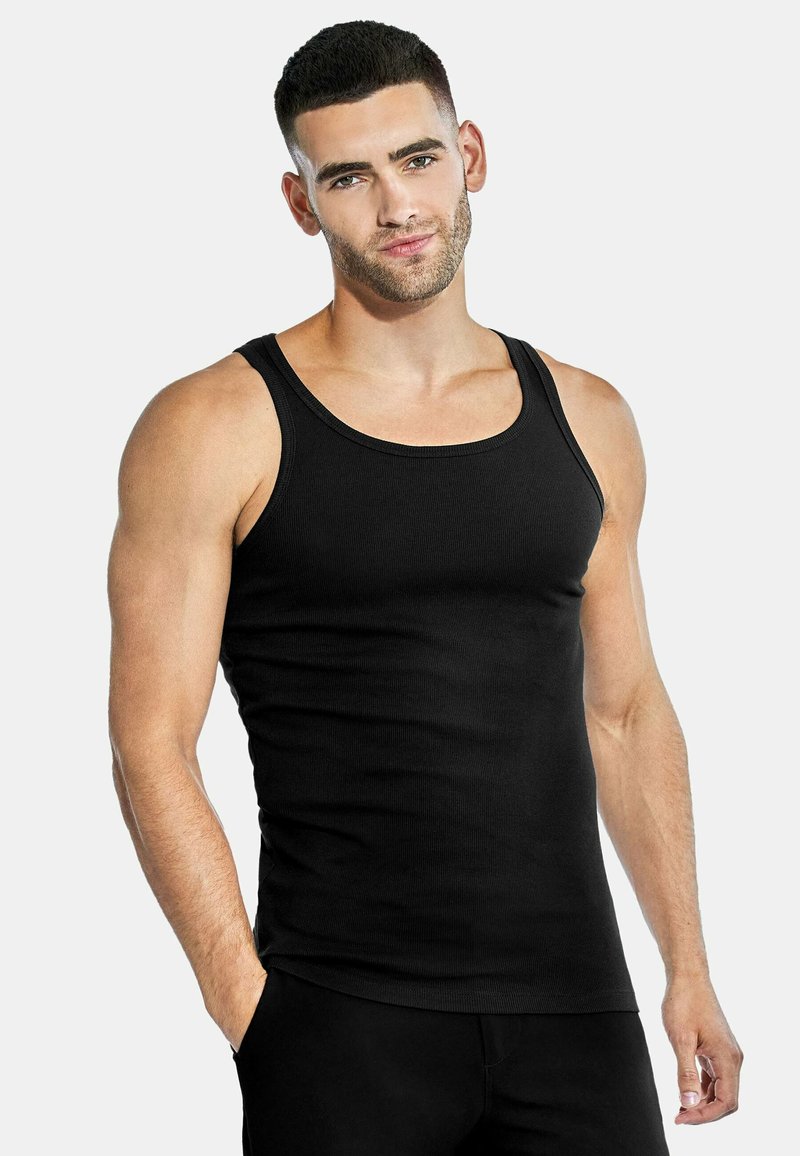 Black ribbed tank top featuring wide straps and a fitted design. Made from soft material, it has a smooth texture and seamless edges.