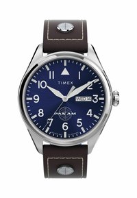 Zegarek Timex z kopertą ze stali nierdzewnej, niebieską tarczą, brązowym skórzanym paskiem, białymi znacznikami godzin i wskazaniem daty z logo Pan Am.