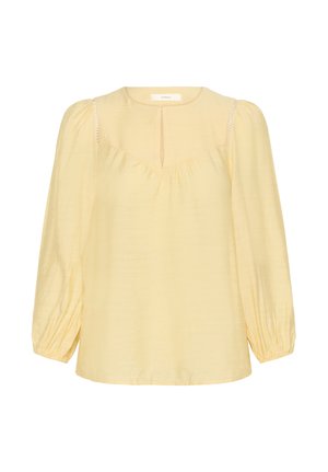 Light yellow long-sleeve blouse with a round neckline, keyhole slit front, gathered yoke, puffed shoulders, and elastic cuffs.