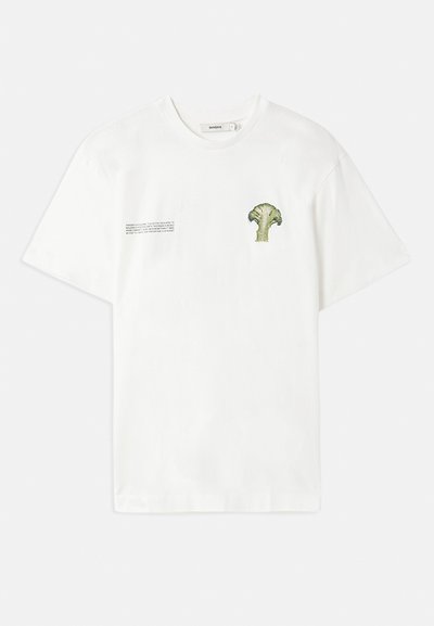 Valkoinen puuvillapaita, jossa on vihreä parsakaalikuva vasemmassa rinnassa ja painettu teksti oikealla puolella. Lyhyet hihat, pyöreä kaula-aukko.