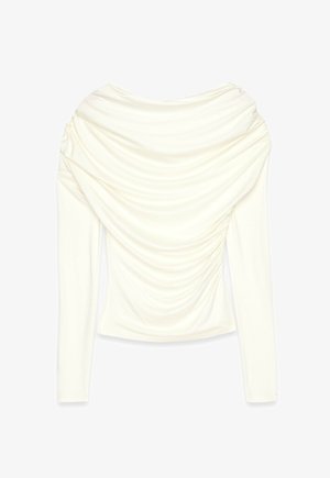 Kreem valge pikkade varrukatega tipp, millel on lai riputatud kaelus ja frontaalne ja varrukatel kogutud rütmijooned.