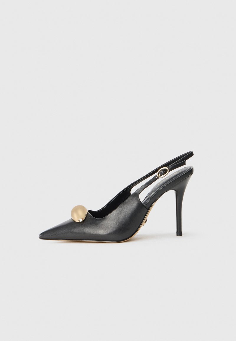 Escarpin slingback en cuir noir à bout pointu avec un talon fin, doté d'un accent boule doré et d'un design ajouré sur les côtés.