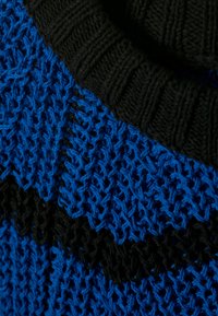 Maglione lavorato a maglia blu e nero con un motivo testurizzato, colletto nero a coste e fili blu intrecciati in un design geometrico.