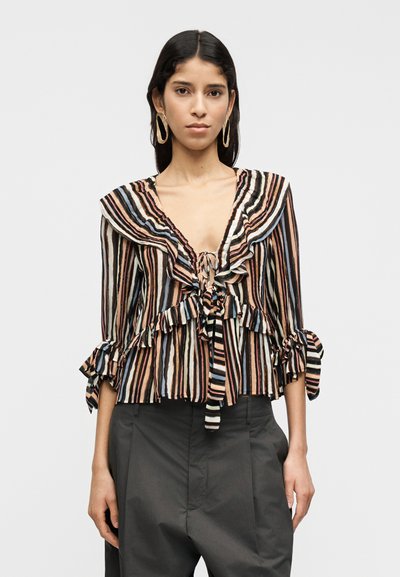 Blouse rayée avec col et manches à volants. Présente un profond décolleté en V et un lien à nouer à l'avant. Le tissu comporte des rayures horizontales variées aux tons terre.