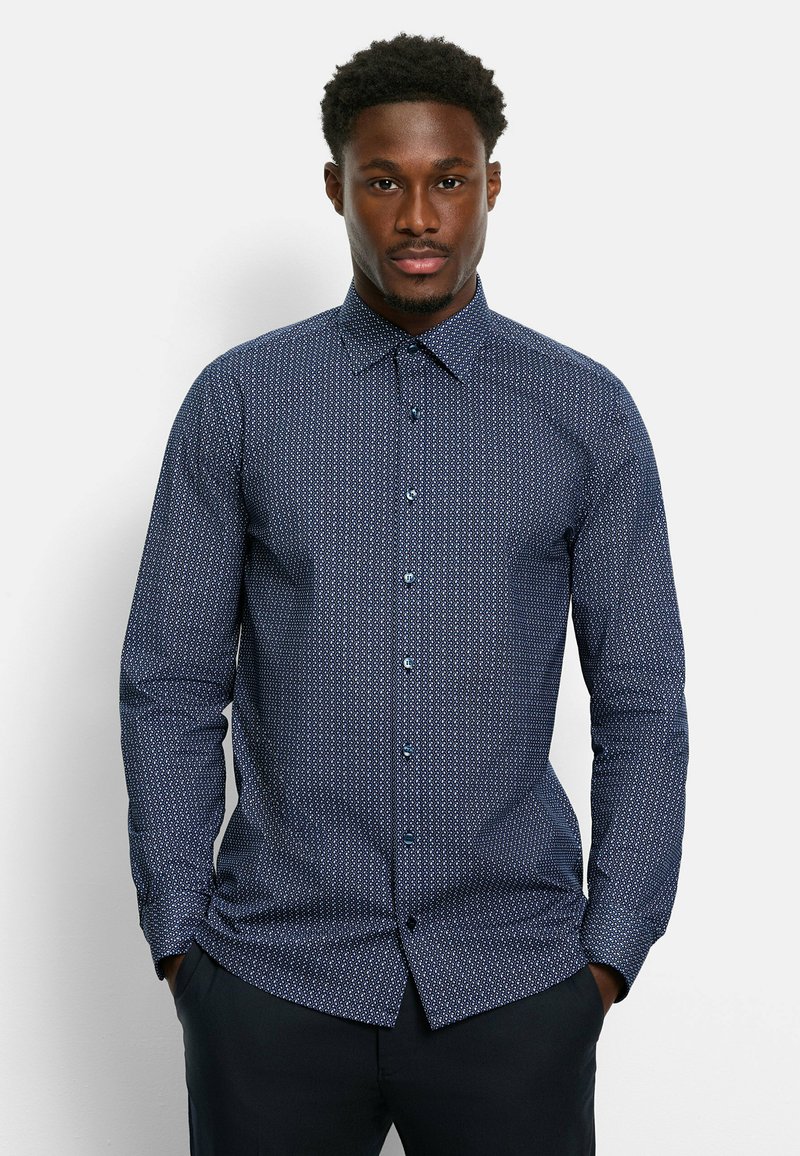 Marineblaues Hemd mit Knopfleiste und kleinem weißen geometrischen Muster, langen Ärmeln, spitzem Kragen und dunkelblauen Knöpfen. Taillierte Passform.