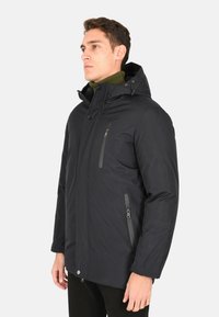 Giacca nera isolata con zip frontale, due tasche con zip, cappuccio e una texture morbida. Dettagli in grigio.