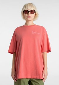 Korallfarbiges, oversized T-Shirt aus Baumwolle mit kurzen Ärmeln und Rundhalsausschnitt, ausgestattet mit einem weißen Vans-Logo auf der Brust.