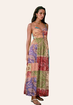 Vestido maxi con tirantes finos, que presenta un diseño de patchwork en colores vibrantes: rojo, verde, púrpura y beige con patrones florales.