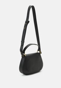 Sac à main en cuir noir de forme structurée, dotée d'une surface texturée et d'accents en métal doré. Il dispose d'une bandoulière réglable et d'une poignée sur le dessus.