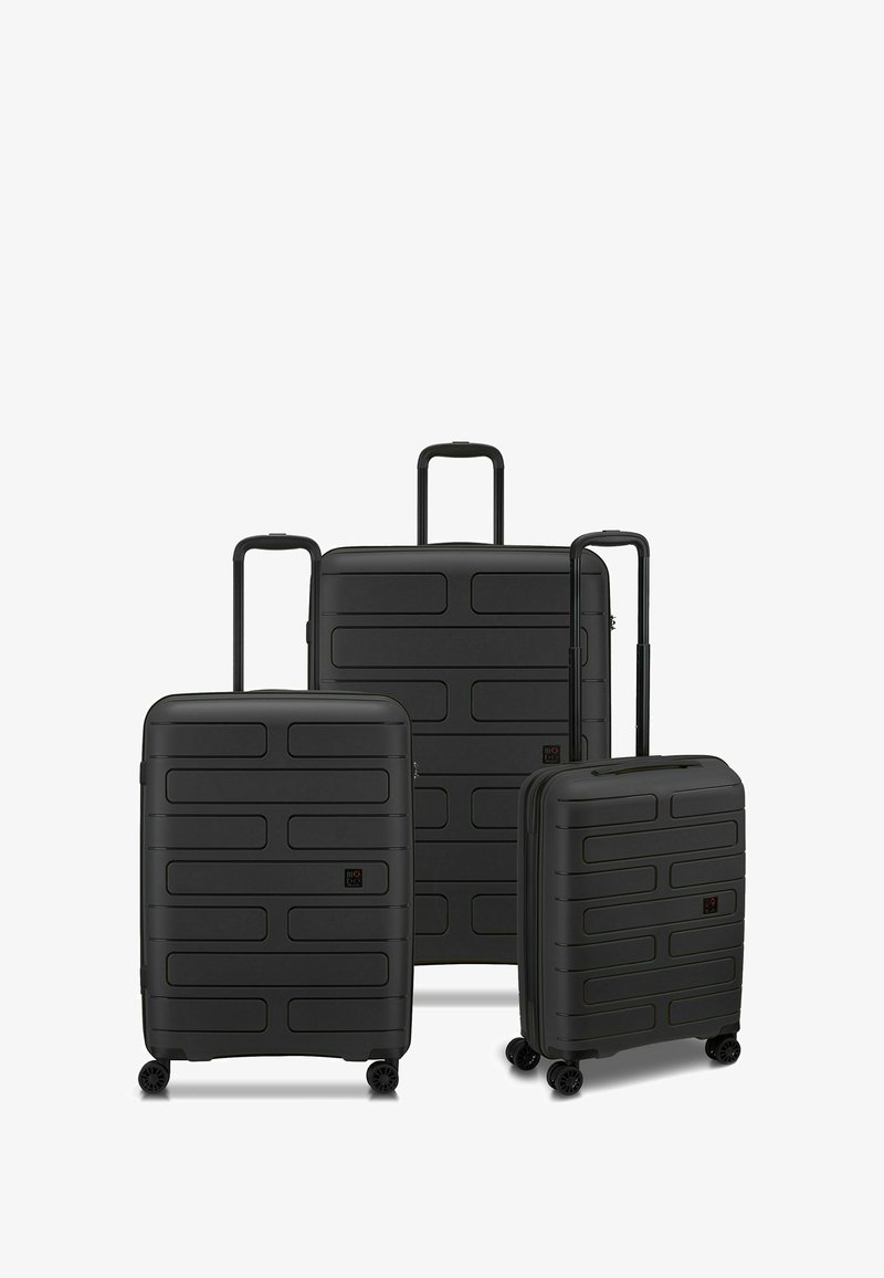 Ensemble de valises rigides noires comprenant trois tailles. Surface lisse et texturée avec des bandes horizontales, des poignées télescopiques et quatre roues.