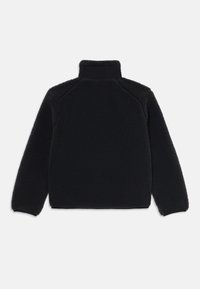Black fleece jacket with a high neck, textured, long sleeves, and a relaxed fit. Features a plain back design without visible fastenings.