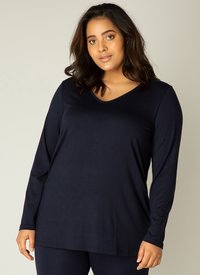 Lange mouwen, V-hals top in marineblauw, gemaakt van zachte stof, met een relaxte pasvorm en minimale stiksels. Gecombineerd met bijpassende onderstukken.