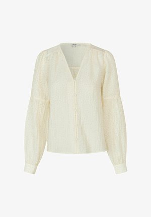 Bluza de culoare crem, cu decolteu în V, mâneci lungi bufante, dungi verticale subțiri și pete aurii subtile. Prezintă închidere cu nasturi în față.