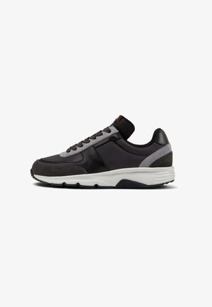 Black and gray sneaker with a mixed material design, featuring leather and suede accents, a textured sole, and lace-up closure.