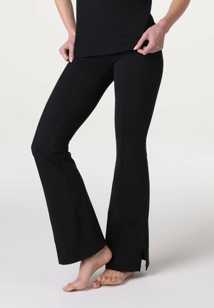 Pantaloni a zampa nera con una texture liscia e elastica. Presentano fessure laterali all'orlo per una maggiore libertà di movimento e un design aderente.