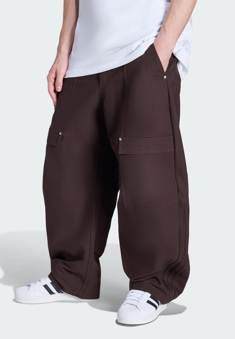 Braune Cargo-Hose mit weiter Beinweite aus weichem Stoff, ausgestattet mit mehreren Taschen, silbernen Metallakzenten und einer glatten Textur mit ausgeprägten Nähten.