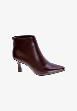 Stivale alla caviglia in pelle marrone con punta affusolata, tacco a stiletto sottile e chiusura con zip sul retro. Texture liscia con una finitura lucida.