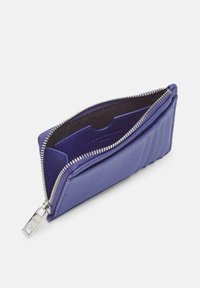 Kompaktowy fioletowy skórzany portfel z srebrnym suwakiem, otwarty, aby pokazać kieszenie na karty i wnętrze.