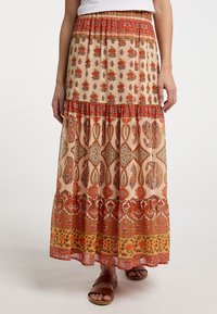 Maxi rok met een beige stof voorzien van rode bloemen en paisleypatronen, gelaagd ontwerp, elastische tailleband en zoom met levendige accenten.