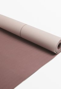 Yoga mat in tinten van mauve en lichtroze, met een gestructureerd oppervlak met golfpatroon, opgerold met gladde randen, gemaakt van flexibel materiaal.