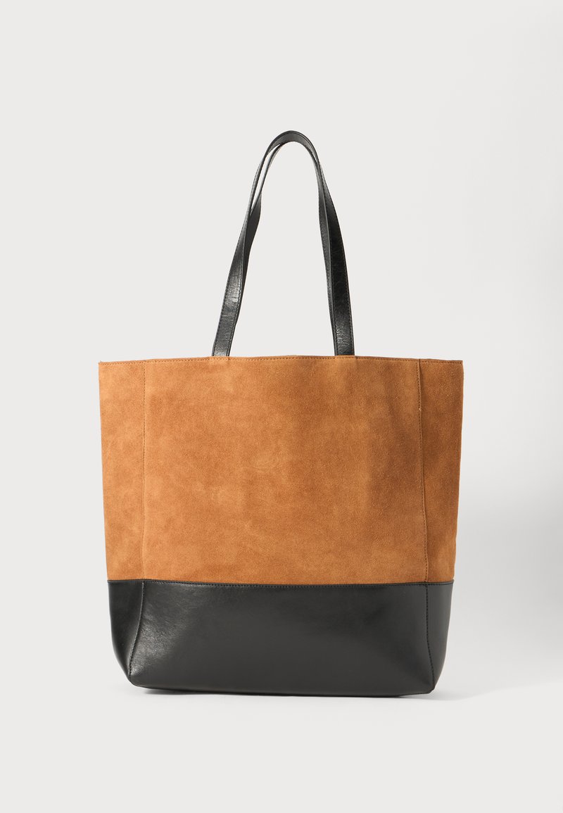 Geantă tote din suede maro cu un fund din piele neagră. Prezintă două mânere din piele neagră. Textură netedă cu un design de culoare solidă.