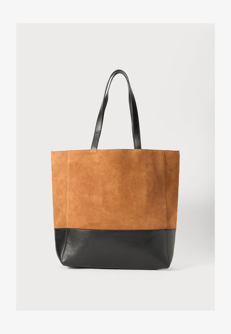 Sac fourre-tout en daim marron avec un fond en cuir noir. Équipé de deux poignées en cuir noir. Texture lisse avec un design uni.