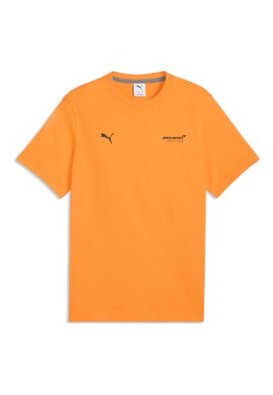 Jasnopomarańczowa koszulka z krótkim rękawem z logo Puma na lewej piersi oraz logo zespołu McLaren Formuły 1 na prawej piersi.