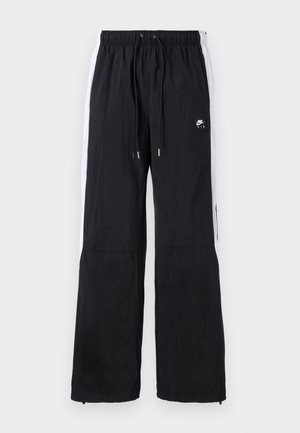 Pantalons de sport noirs avec taille élastique, bandes latérales blanches, poignets zippés et un logo en caoutchouc sur le devant.
