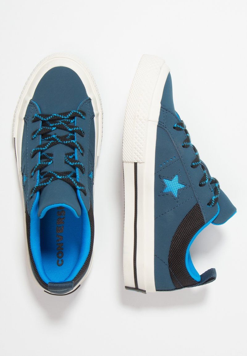 Modré a šedé tenisky s černými síťovanými detaily, bílými gumovými podrážkami a modrým hvězdným motivem. Mají černé a modré tkaničky, strukturovaný materiál.